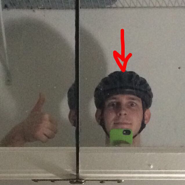 Jamison staring at a distorted giving a thumbs up with a bicycle helmet on