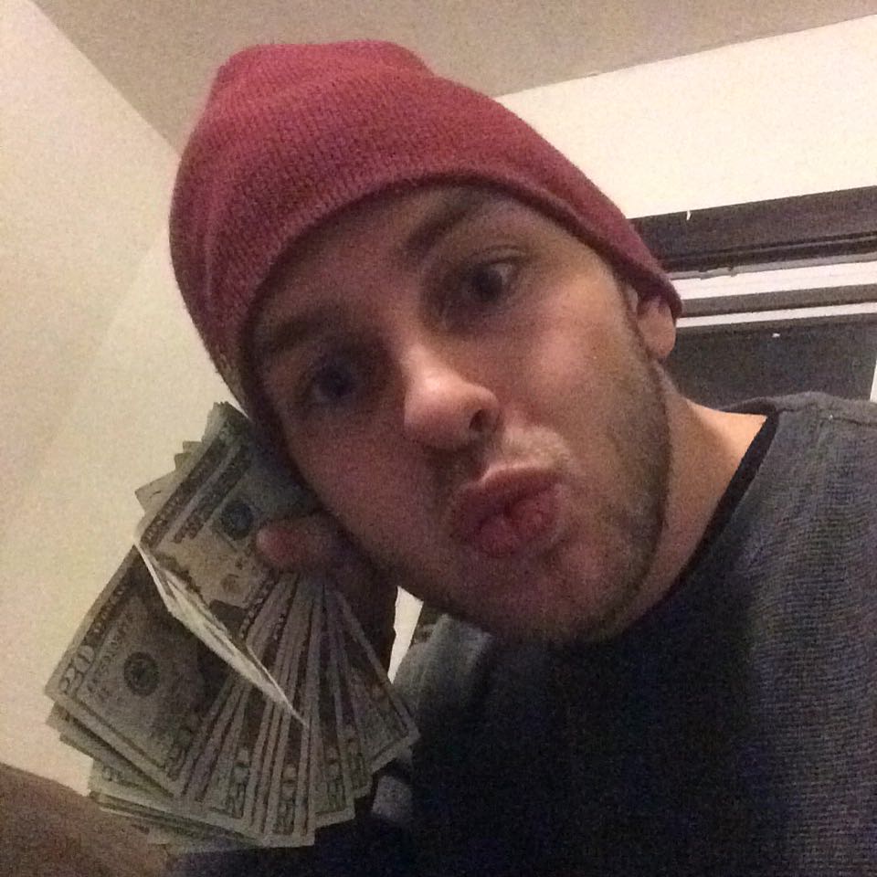 Jamison duck-facing with money next to his ear like a phone