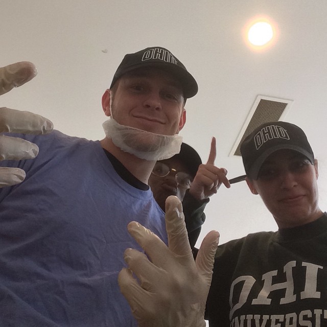 Jamison in cafeteria work outfit pointing towards the sky with coworkers